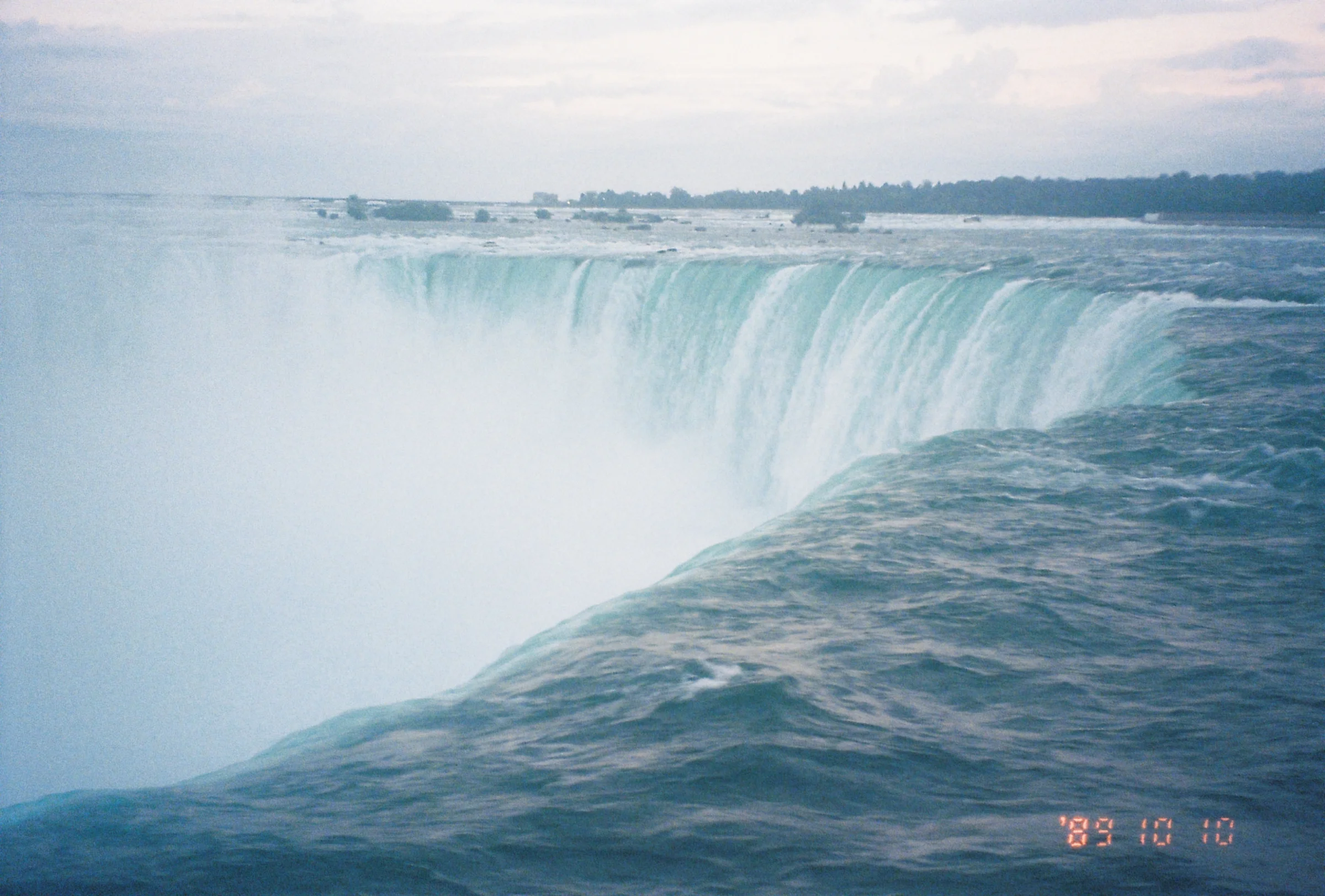 A still of niagara falls, curved around its cliff.